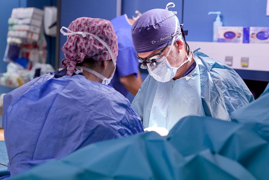 Dr Lior Amsallem au bloc opératoire, en tenue de chirurgien, pendant une intervention de chirurgie de la main