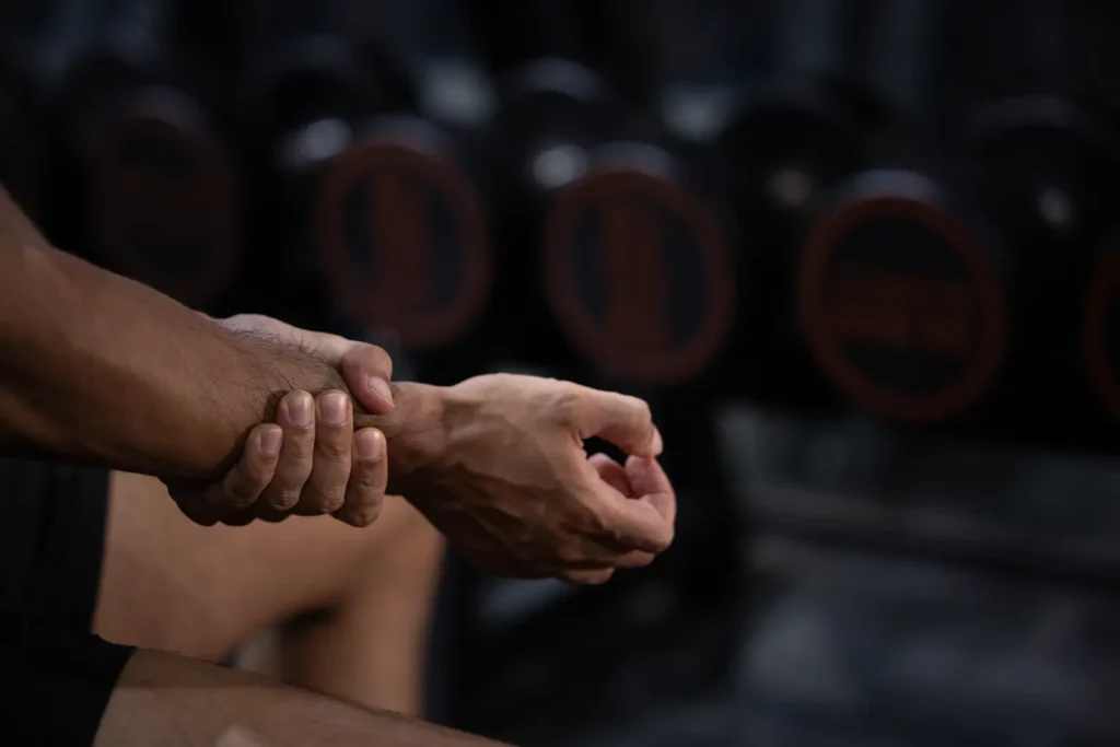 Homme dans une salle de sport qui se tient le poignet